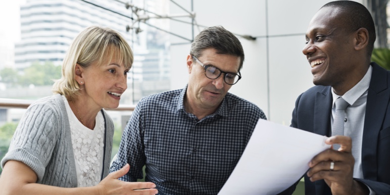 A middle-aged couple being shown a page of their printed will.