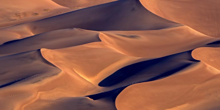 Sand dunes in a dessert at dusk.