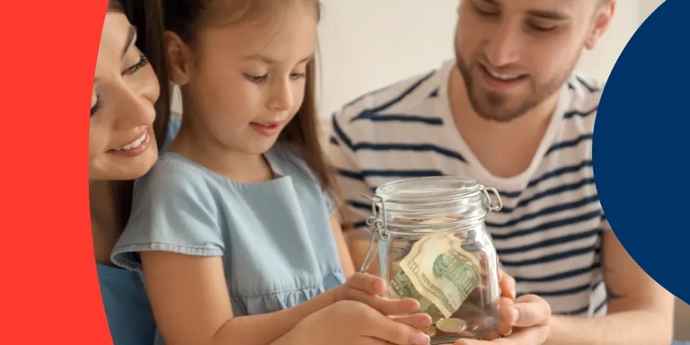 Husband and wife beside their daughter, showing her the importance of saving by helping her hold a glass jar filled with money.
