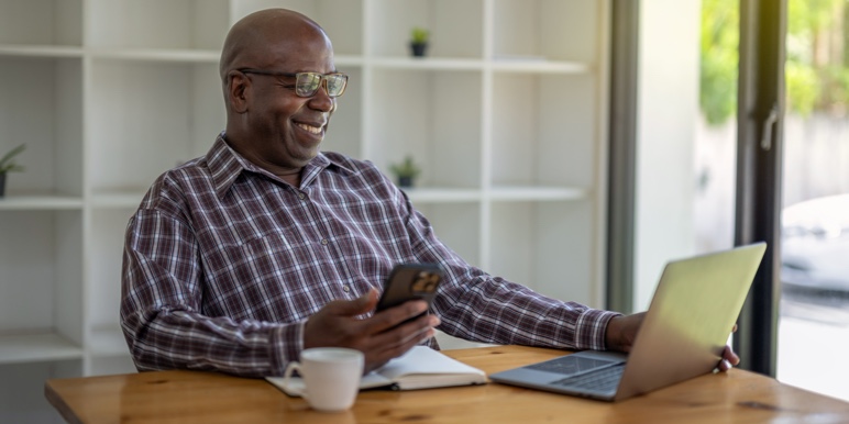Retired man using digital tools to plan his monthly finances with annuity income.
