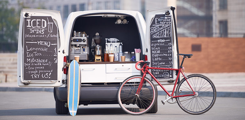 A mobile coffee business with a van and bicycle, representing the need for business car insurance in South Africa to protect commercial vehicles.