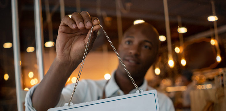 A business owner inspecting a glass window, emphasising protection for fixed glass installations in commercial premises.