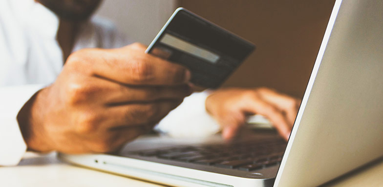 A person making an online payment using a credit card and laptop, representing financial security and business cash protection.