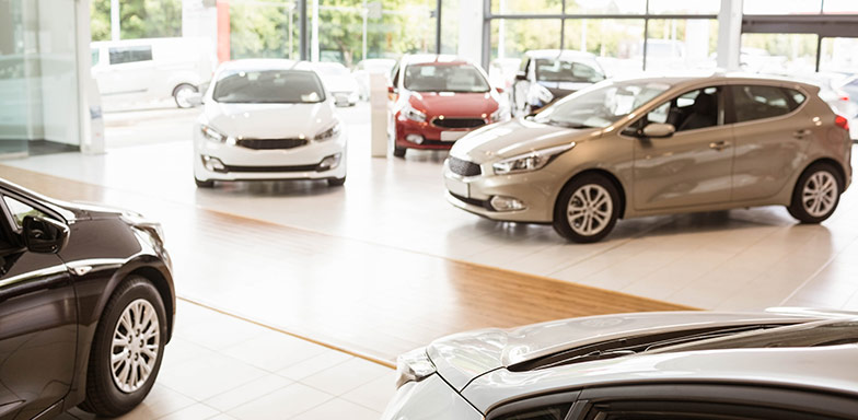 A car dealership showroom with multiple vehicles, representing motor trade insurance coverage for businesses.