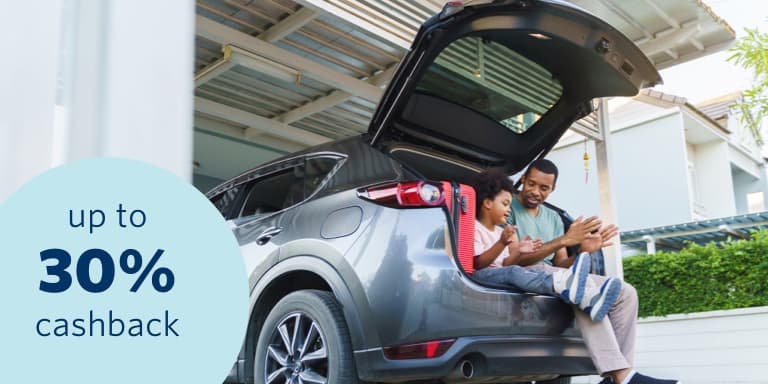 A man with his son sitting in the boot of his insured SUV with a 30% cashback benefit.