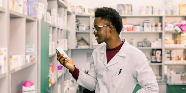 A pharmacist taking out prescription medication for his customer who uses the Chronic Benefit from their medical aid with Momentum.