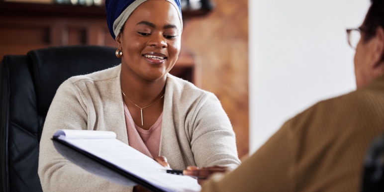 A helpful female financial adviser assisting a client with a trustee-approved guaranteed life annuity application.