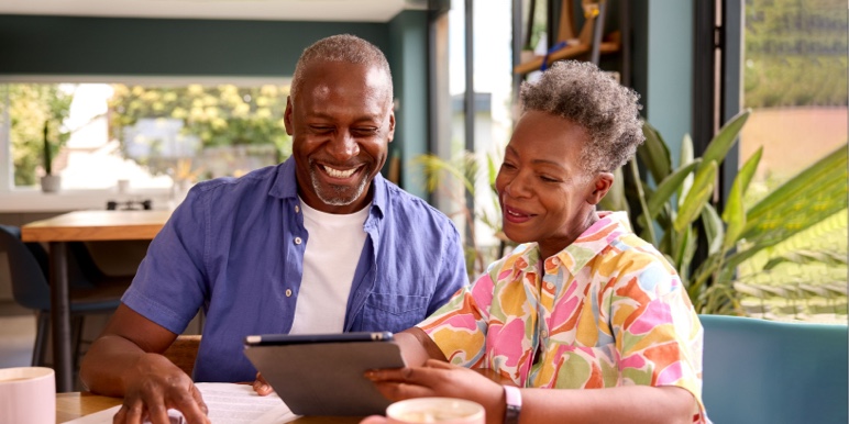 Middle-aged African couple reviewing their retirement annuity contracts on a tablet. 