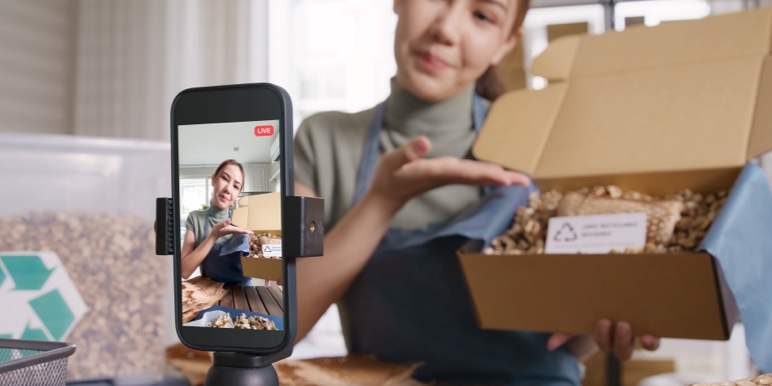 A content creator shooting herself unboxing a package.