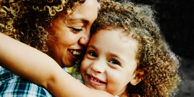 A young mom hugging her daughter.