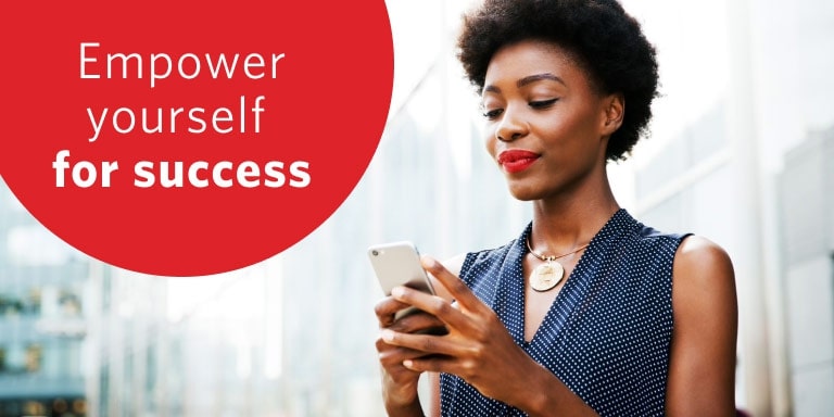 A female professional on her mobile phone outside an office building accessing FundsAtWork resources.