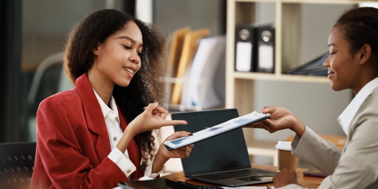 Two young female professionals at an office, in consultation about retirement.