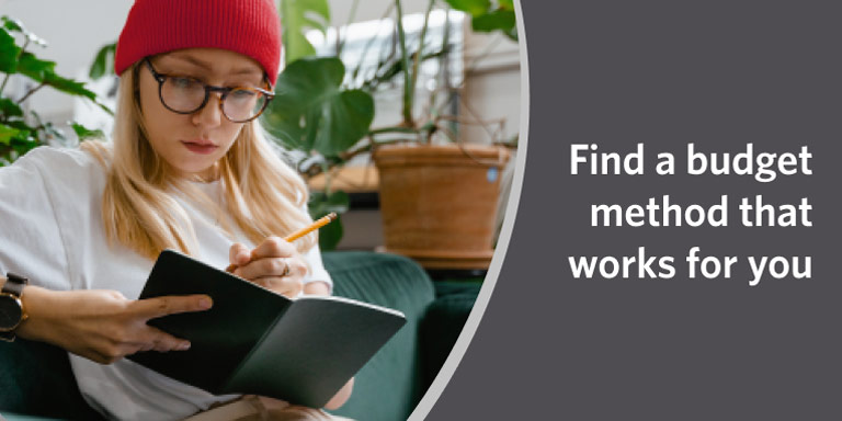 Woman in red beanie writing in a notebook in a video on different budgeting methods.