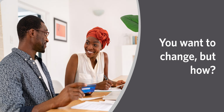 Two people in discussion at a table with a laptop in a video about financial life hacks.