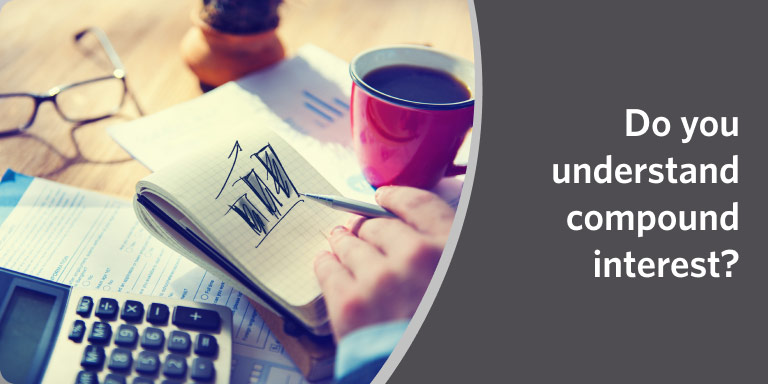 Notebook and coffee on a table with someone writing in a video about compound interest.