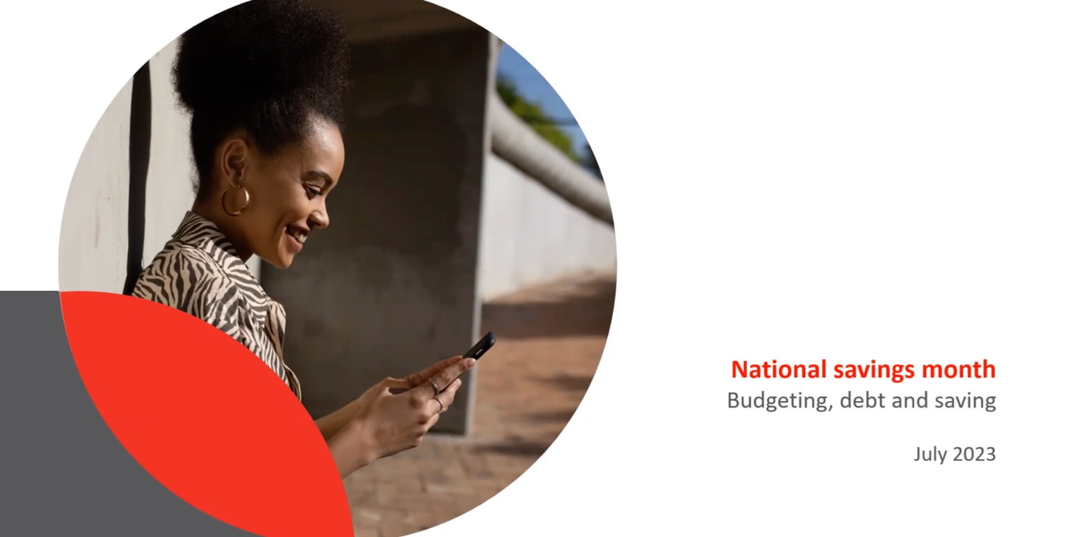 A young woman glances at her cell phone, exploring insights and tips about Savings Month.