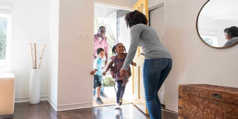 Group Insurance Dad with young son and daughter running happily to greet their mom. 