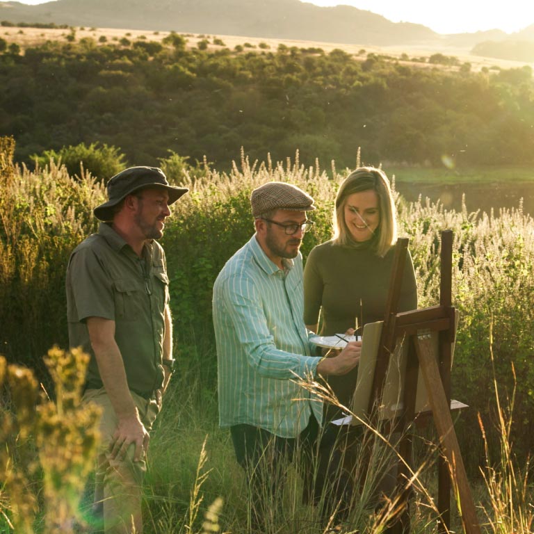 Silhouette of three adults against the backdrop of a sunset.