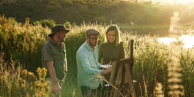 Silhouette of three adults against the backdrop of a sunset.