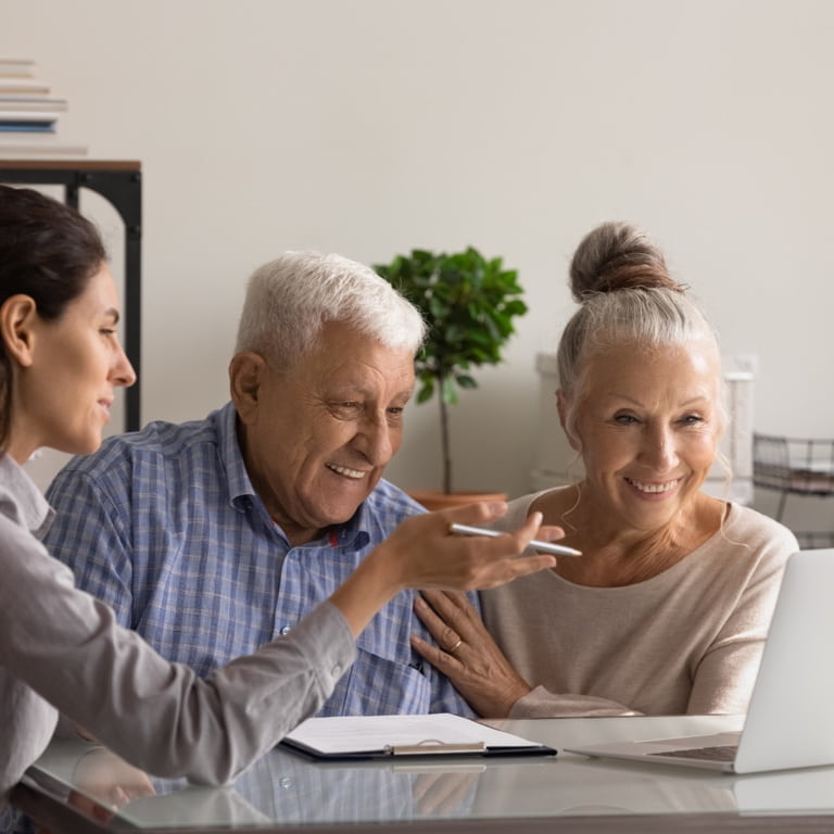 A couple in their retirement years sitting with their financial adviser chatting about the two-pot retirement system.