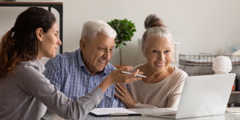 A couple in their retirement years sitting with their financial adviser chatting about the two-pot retirement system.