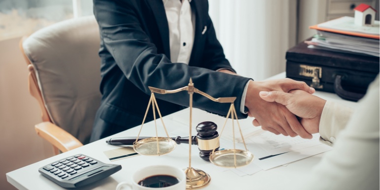 A legal expert shaking hands with a client after a deceased estate has been properly settled.