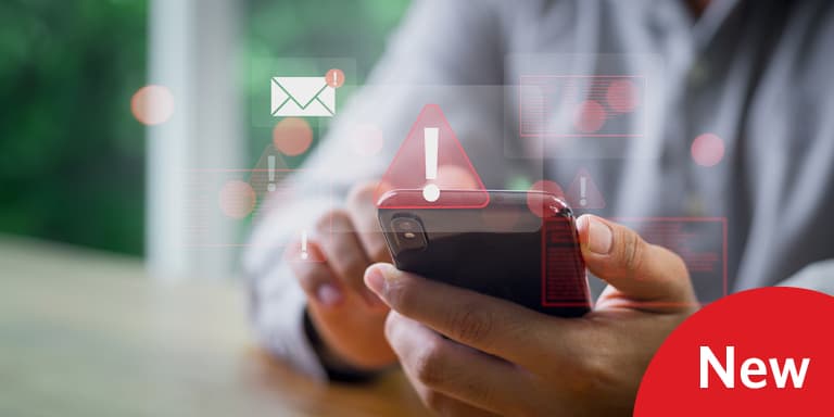 Person’s hands holding a smartphone with digital warning icons and alert symbols, representing cybersecurity and digital safety awareness.
