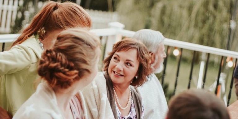 Women with pearls chatting.