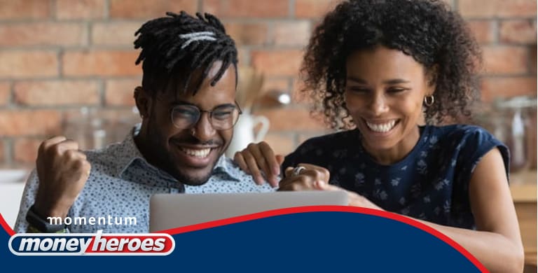 A happy young couple watching Money Heroes content on their laptop and feeling energised and inspired by the financial advice.
