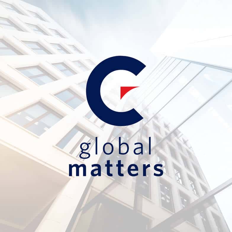 The Momentum Global Matters logo against a faded multistory office building backdrop and a light blue sky.