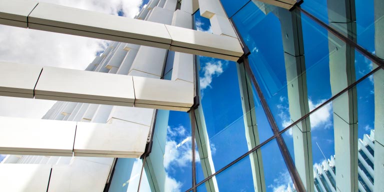 Smiling little child wearing glasses and holding books above her head.
