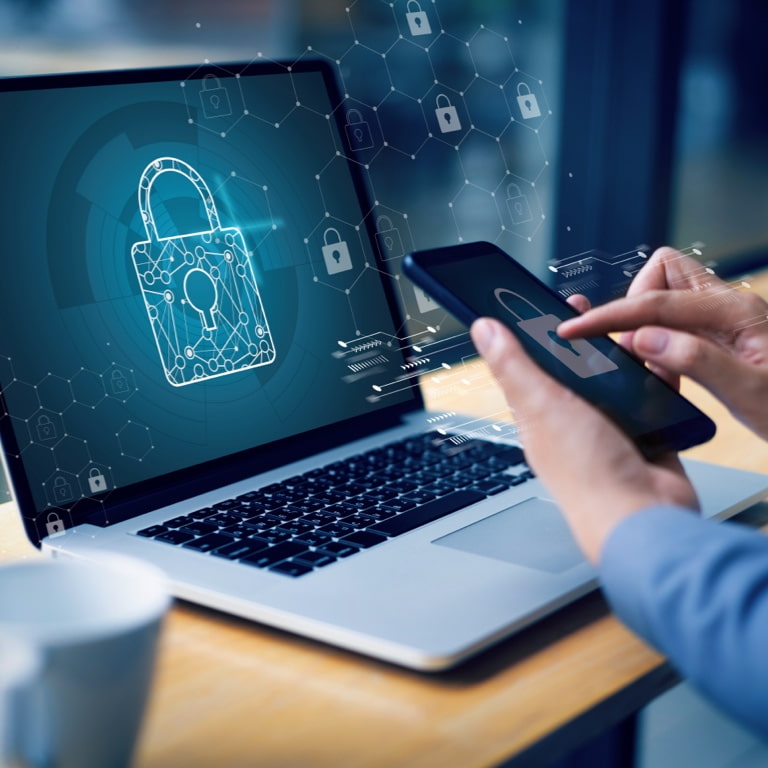 A man is sitting in front of a laptop. A padlock on the laptop indicates that data on the laptop is encrypted.