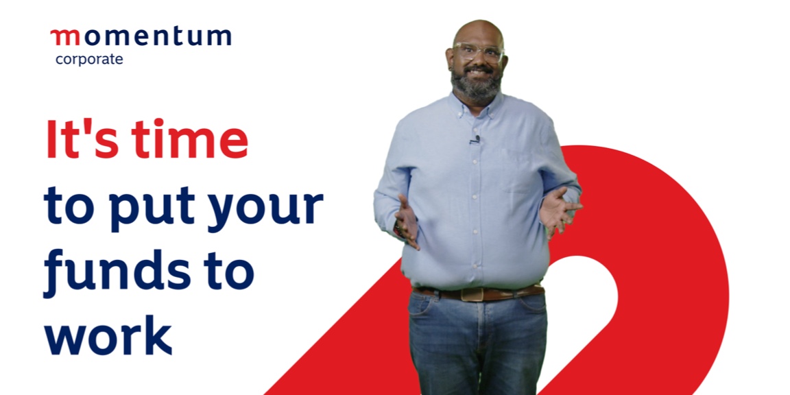 Traven Govender, Retirement Benefit Councillor at Momentum Corporate, stands against a white Momentum-branded background and speaks about two-pot withdrawals.