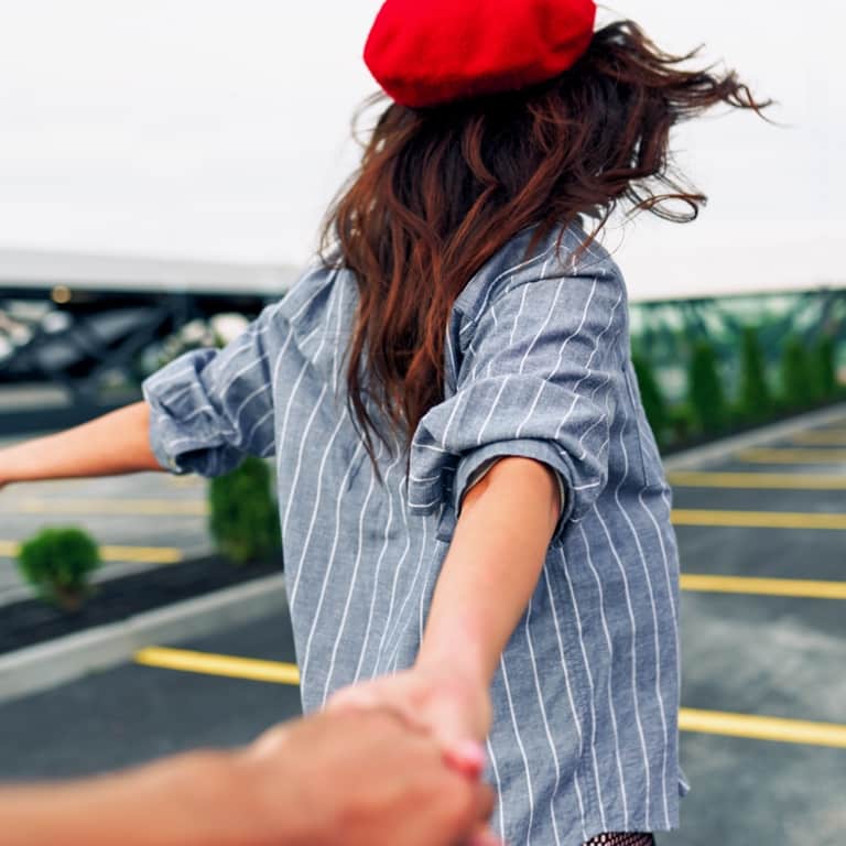 Young, happy woman wearing a red beret with the wind in her hair.