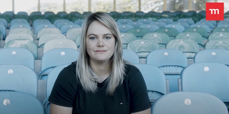 Dane van Niekerk, sitting down facing forward in the stands of a cricket stadium.