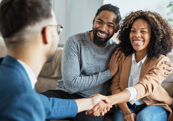 Smiling couple meeting with a financial advisor, discussing future financial planning.