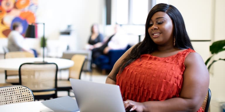 A young woman viewing the Momentum Corporate website on her laptop.
