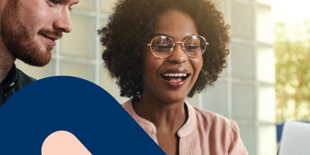 A young female professional at her laptop with her  financial adviser, reviewing her retirement fund beneficiaries. 