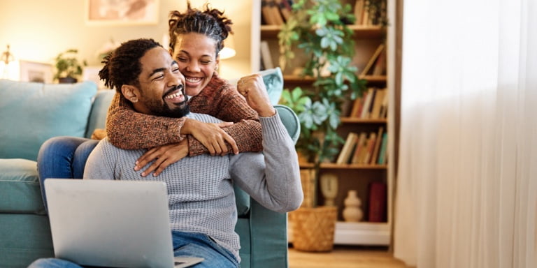 Young couple sitting on the floor of their living room, drafting their Will as part of the estate planning process