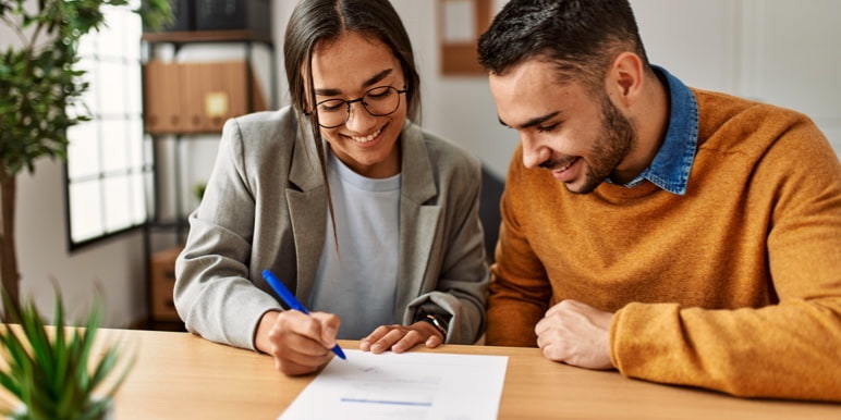 A young couple signing a Will.