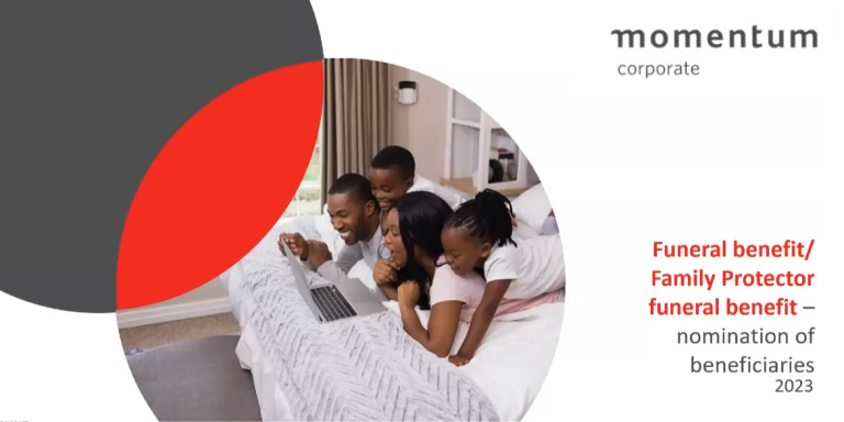 A young family—mom, dad, and their two kids—lie together on a bed, enjoying time gathered around a laptop.